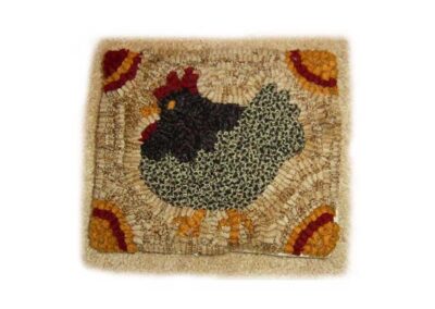 Hand-hooked wool rug featuring a speckled hen design with corner floral accents