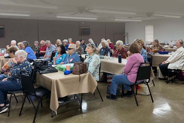 Guild Members Gather for a Program Meeting Group of quilters seated at tables during a Texas Star Quilters Guild program meeting